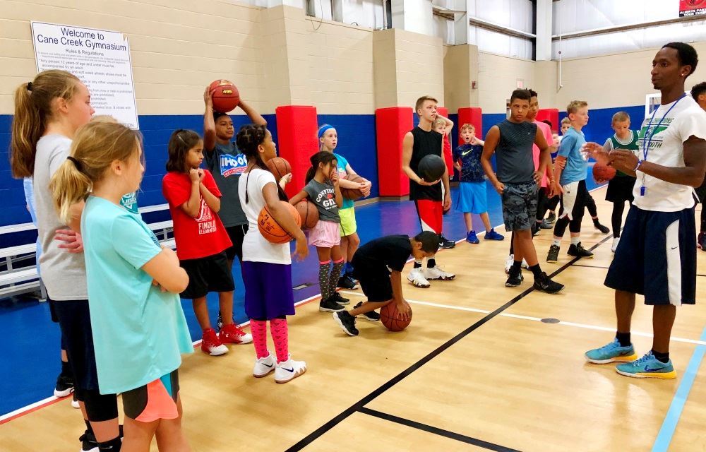Kids gather during basketball camp at Cane Creek Gymnasium.