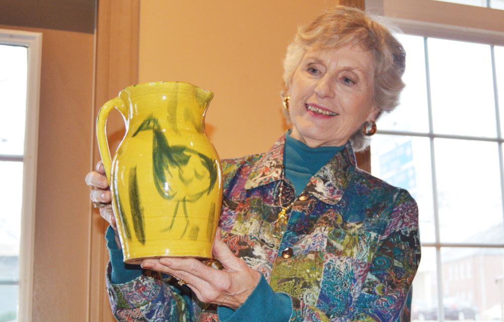 A women holds pottery.