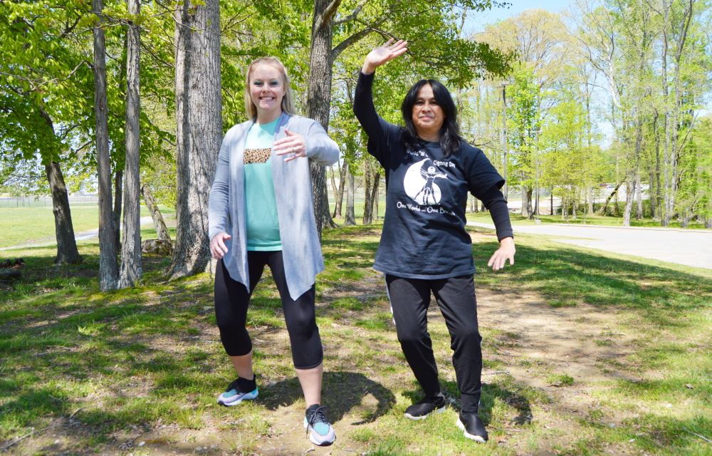 Women practice tai chi movements.