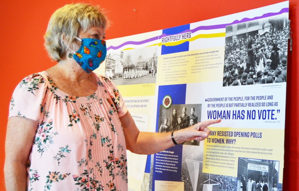 A museum docent looks at the Suffrage Centennial 1920-2020 exhibit at Cookeville History Museum.