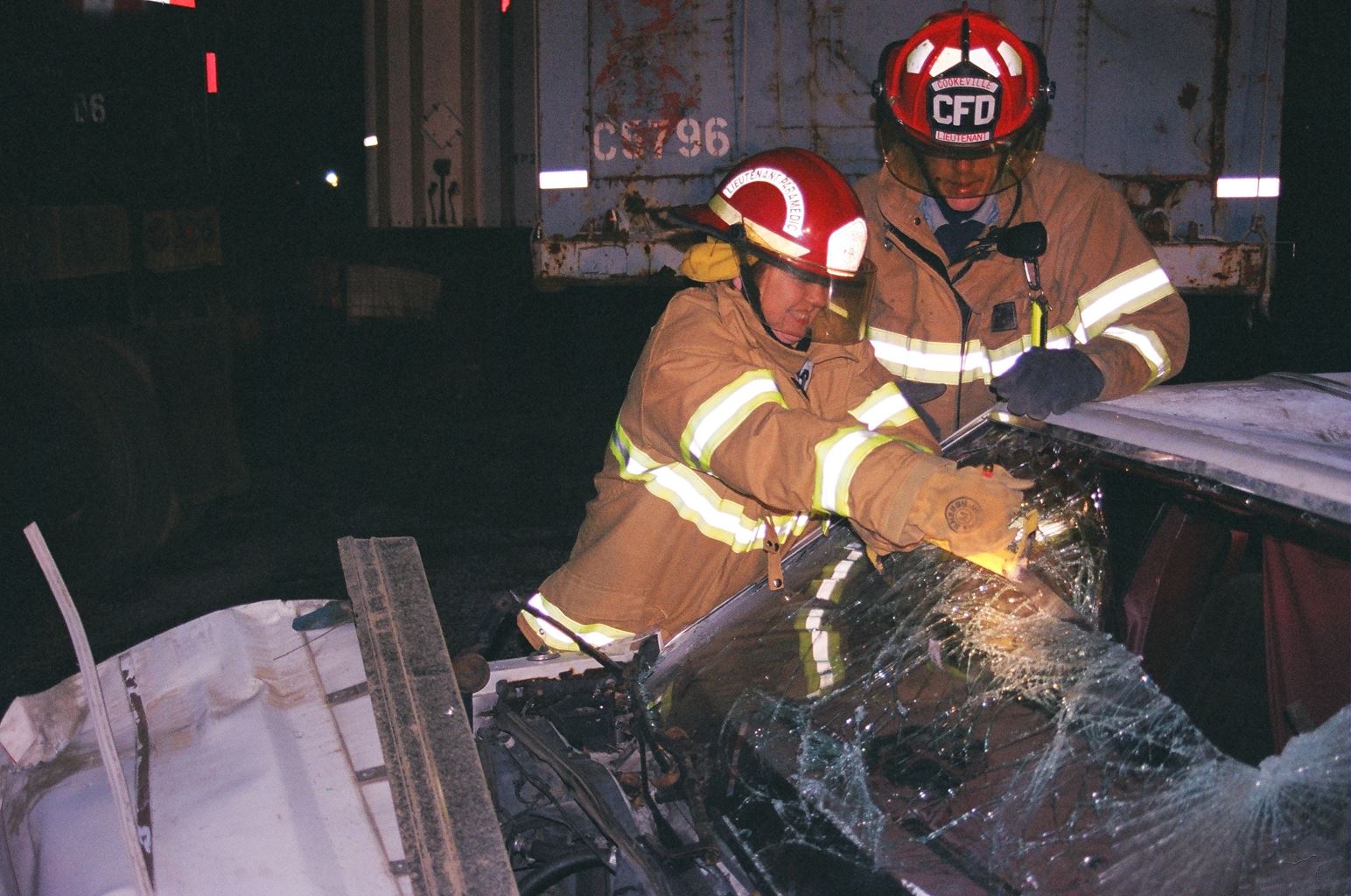 Fire Fithers Working on a Broken Car Glass