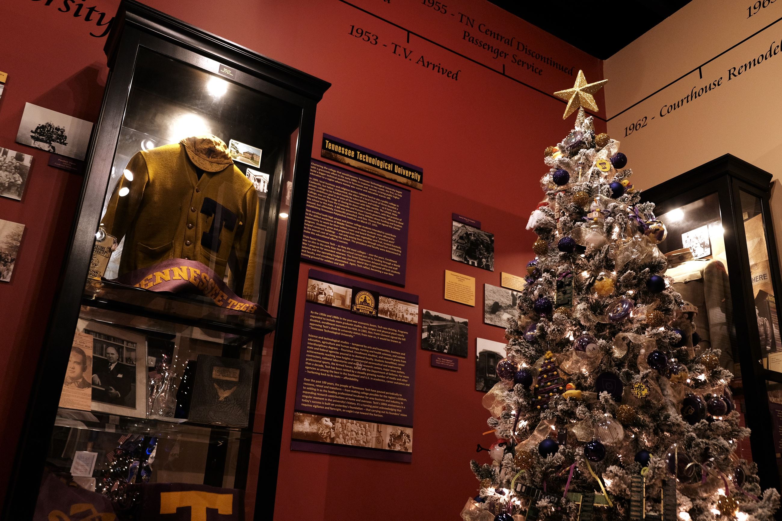 The TTU Computer Science themed Christmas tree next to a display of a vintage TTU varsity jacket.