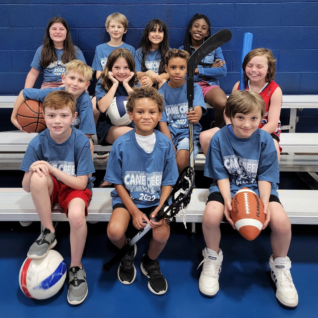 group of camp kids all holding different sports equipment 