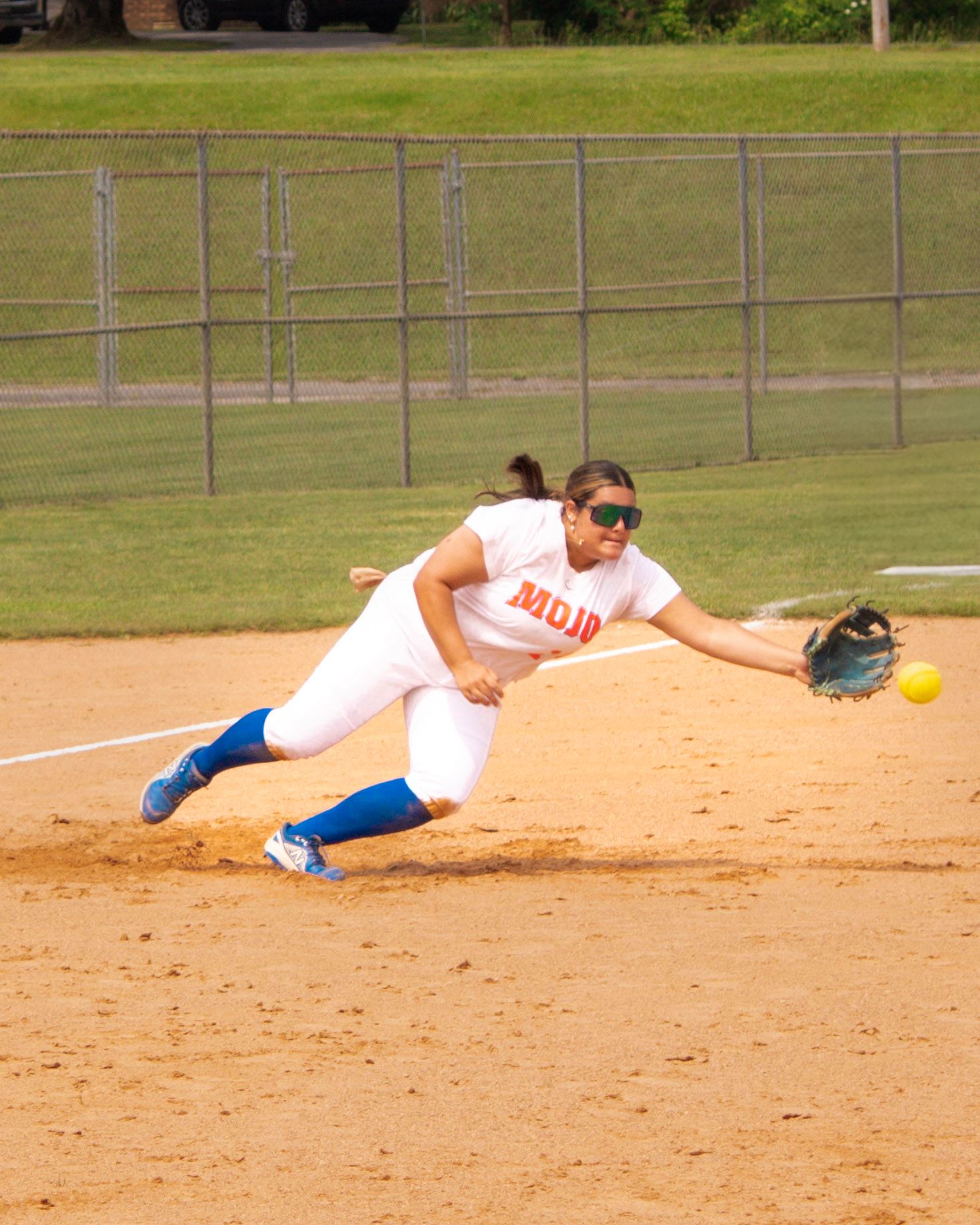 softball player diving to catch the ball